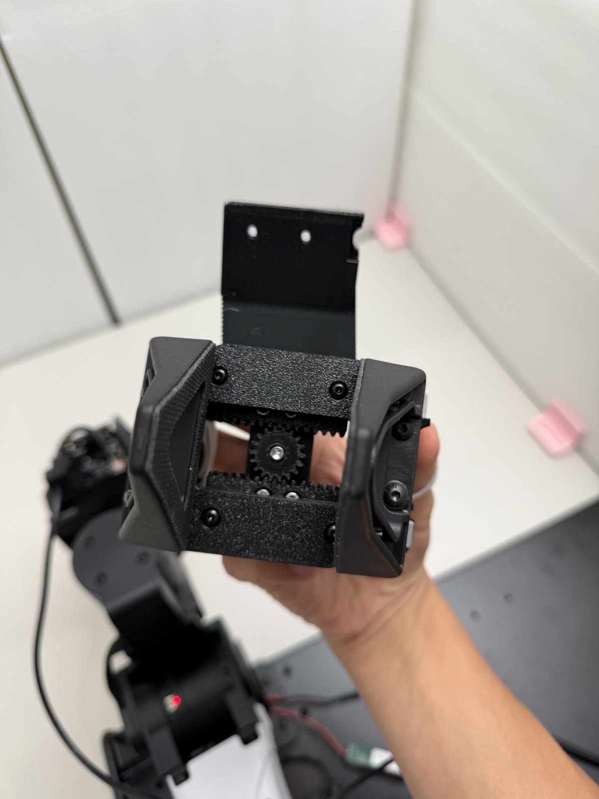 Viewed from the gripper tip side: a central pinion meshing with a rack on each jaw.
